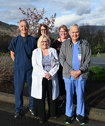 The team at Mount Jefferson Family Medicine is committed to providing high-quality care for all ages, ranging from pediatric care to adult family medicine.Picture of The Mount Jefferson Family Medicine Staff standing outside in front of trees and a mountain