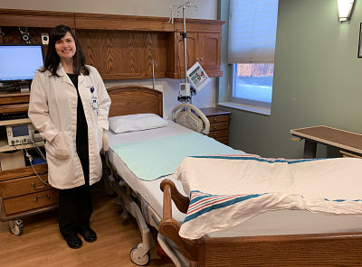 Picture of Dr. Tara Burgher standing in a hospital room smiling