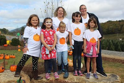Picture of Michelle Carpenter and the Girl Scouts at a Pumpkin Patch smiling in pumpkin painted t-shirts