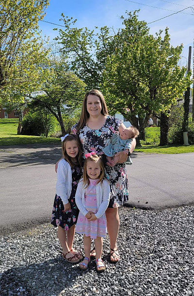 Picture of Jessica Rupard standing outside with her two young daughters and newborn baby girl