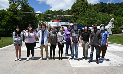 Picture of a group of students standing outside in front of a helicopter.
Eleven students in grades 9-12 participated in this year's camp, which was designed to expose students to the various aspects of medicine and potential career opportunities available to them should they decide to pursue a career in healthcare.