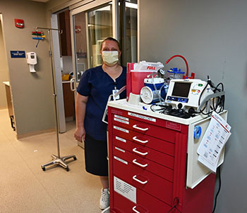 Picture of AMH Nurse Sheila Matiba wearing a mask standing in the Hospital Hallway next to some medical machinery. She is wearing a mask. Sheila Matiba has been named 2022 Great 100 Nurses.
Ashe Memorial Hospital is pleased to announce that Monitored Bed Unit nurse Shelia Maltba has been named a 2022 Great 100 Nurse.