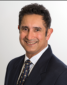 Headshot of male physician in suit and tie.